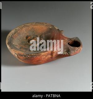 Lamp, concave top. Culture: Cypriot. Dimensions: Overall: 1 1/16 x 3 5/8 in. (2.7 x 9.2 cm). Date: 1st century B.C.-1st century A.D.. Museum: Metropolitan Museum of Art, New York, USA. Stock Photo