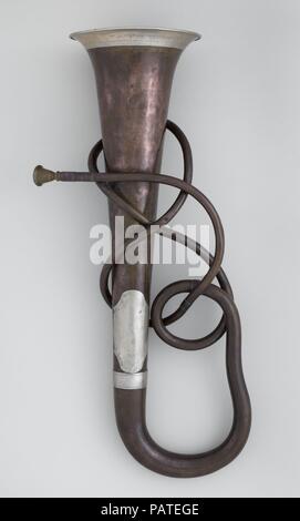 Tenor Bugle in B-flat. Artist: Josef Serpek (Austrian, fl. 1862-?). Culture: Austrian. Dimensions: Height: 26 15/16in. (68.4 cm)  Diameter (Of bell): 7 11/16 in. (19.6 cm)  Weight: 2.2 lbs. (997.913 g). Date: ca. 1862.  Although Mary Elizabeth Adams Brown purchased this instrument from Leopoldo Franciolini, who has become infamous for selling forged and fantastical instruments, there is no reason to assume that this instrument is a fake. Instead, its fanciful configuration suggests that it was made for use in a carnival parade or historical pagentry event. Museum: Metropolitan Museum of Art, N Stock Photo