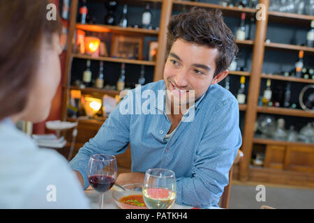 happy young couple in restaurant waiting for food and talking Stock Photo