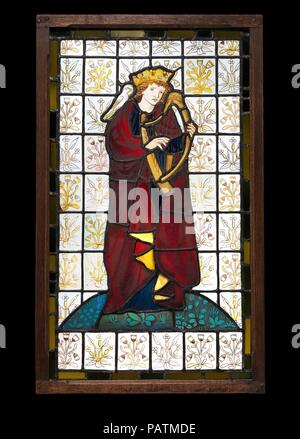 King David the Poet. Culture: British, London. Designer: Figure designed by Sir Edward Burne-Jones (British, Birmingham 1833-1898 Fulham); Background designed by William Morris (British, Walthamstow, London 1834-1896 Hammersmith, London). Dimensions: Overall: 32 1/2 × 19 1/2 in. (82.6 × 49.5 cm). Manufactory: Morris, Marshall, Faulkner & Co.. Date: 1863.  This panel of King David, with three other panels also decorated with figures of poets (Homer, Chaucer, and Dante), was made for windows in the breakfast room at Silsden, a house in Yorkshire built for textile manufacturer Charles Hastings. T Stock Photo