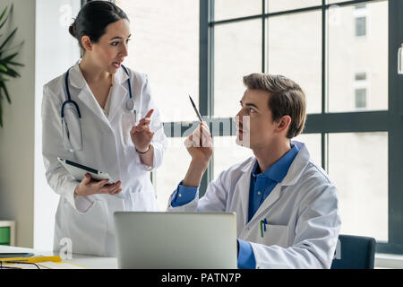 Young female physician asking for advice from her experienced colleague Stock Photo