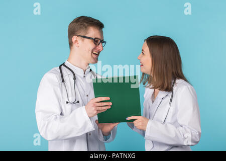 Studio portrait of happy male and female doctors with documents in hands Stock Photo