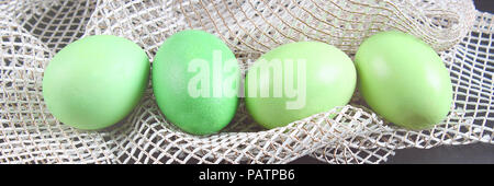 green easter eggs lie on white cloth. Stock Photo