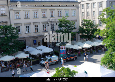 Rooftop view looking down on tourists enjoying their meals and drinks under the sun Parasols, Main Square, Krakow, Poland,Europe. Stock Photo