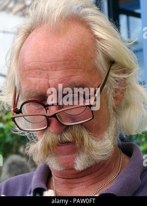 Silver haired man wearing two pairs of glasses at the same time. Property and Model released Stock Photo