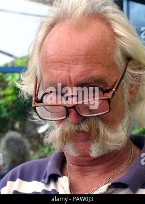 Silver haired man wearing two pairs of glasses at the same time. Property and Model released Stock Photo