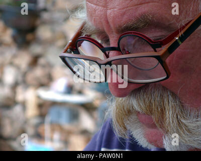 Silver haired man wearing two pairs of glasses at the same time. Property and Model released Stock Photo