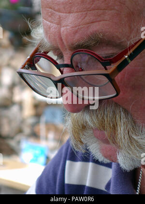 Silver haired man wearing two pairs of glasses at the same time. Property and Model released Stock Photo