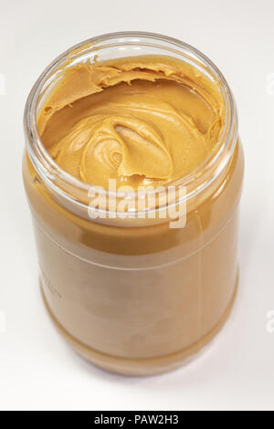 A jar of organic peanut butter sitting on the kitchen table waiting to be eaten Stock Photo