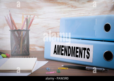 Amendments. Office Binder on Wooden Desk. On the table colored pencils, pen, notebook paper Stock Photo