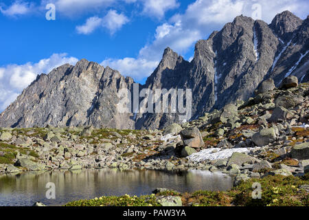 Small lake in hanging valley and mountain peaks in background. Eastern Sayan. Russia Stock Photo