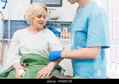 Nurse caring for patient in recovery room of hospital Stock Photo
