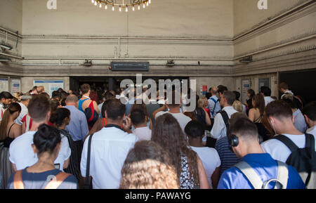 Morden Underground Station, London, UK. 25 July, 2018. Southern terminus station on the Northern Line is closed at 08.20am during the peak of the morning rush hour due to a reported fire incident in the south bound tunnel. All trains to and from Morden stopped while the incident was investigated, with large build up of passengers outside the station. Credit: Malcolm Park/Alamy Live News. Stock Photo