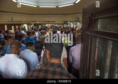 Morden Underground Station, London, UK. 25 July, 2018. Southern terminus station on the Northern Line is closed at 08.20am during the peak of the morning rush hour due to a reported fire incident in the south bound tunnel. All trains to and from Morden stopped while the incident was investigated, with large build up of passengers outside the station. Credit: Malcolm Park/Alamy Live News. Stock Photo