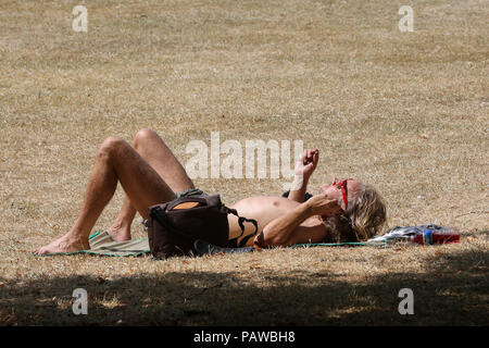 Hyde Park. London. UK 25 June 2018 - A man sunbathes on burnt parched grass in Hyde Park on a very hot and humid day in the capital. According to the Met Office the temperature in London and South East is likely to reach 35 degree celsius on Thursday.     Credit: Dinendra Haria/Alamy Live News Stock Photo
