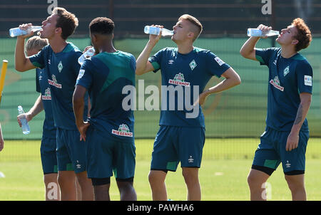 Bremen, Germany. 25th July, 2018. Sebastian Langkamp (l-r), Jean-Manuel Mbom, Ole Kaeuper and Josh Sargent from soccer club SV Werder Bremen, drink and refresh themselves during a training break. The heat wave over northern Germany is proving to be a challenge for the football professionals. Credit: Carmen Jaspersen/dpa/Alamy Live News Stock Photo