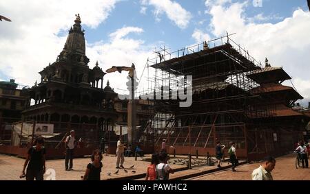Lalitpur, Nepal. 25th July, 2018. People walk around the reconstruction site of Patan Durbar Square in Lalitpur, Nepal, on July 25, 2018. Reconstruction process is undergoing in Patan Durbar Square as many temples were badly damaged in the earthquake in 2015. Credit: Sunil Sharma/Xinhua/Alamy Live News Stock Photo