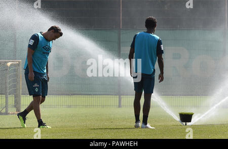 Bremen, Germany. 25th July, 2018. Max Kruse (l) and Theodor Gebre Selassie of Bundesliga soccer club SV Werder Bremen, refresh themselves during a training session. The heat wave over northern Germany is proving to be a challenge for the football professionals. Credit: Carmen Jaspersen/dpa/Alamy Live News Stock Photo