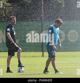 Bremen, Germany. 25th July, 2018. Max Kruse (r) of Bundesliga soccer club SV Werder Bremen and manager Florian Kohfeldt, refresh themselves during a training session. The heat wave over northern Germany is proving to be a challenge for the football professionals. Credit: Carmen Jaspersen/dpa/Alamy Live News Stock Photo