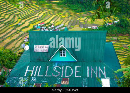 Green roof of rustic tourist inn overlooking stunning, lush rice terraces in the village of Batad - Luzon, Philippines Stock Photo