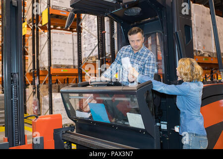 warehouse manager checking her inventory in a large warehouse Stock Photo