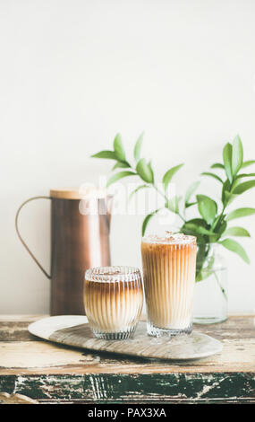 Iced coffee drink in tall glasses with milk on board Stock Photo