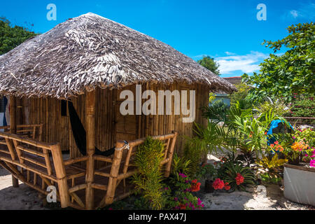 A rustic Filipino island bungalow with hammock and flowers in the garden - Malapascua, Cebu - Philippines Stock Photo