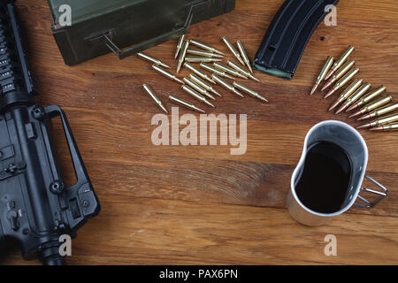 rifle and cup of coffee on wooden table background Stock Photo