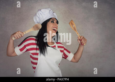 funny woman with wooden spoons on gray background Stock Photo