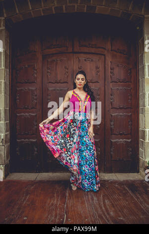 Girl with colorful dress in front of a door Stock Photo