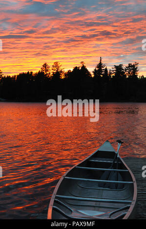 Canoe on dock at sunset sunrise on Lake One in the Boundary Waters Canoe Area near Ely Minnesota Stock Photo