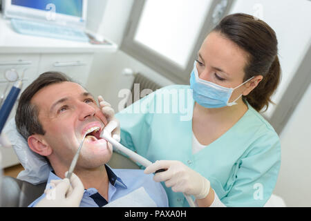 female dentists working on young male patient Stock Photo