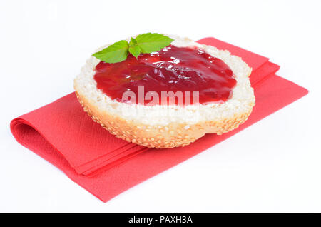 A fresh roll with redcurrant jelly, decorated by mint leaves Stock Photo