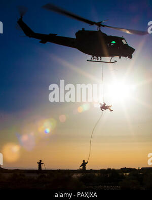 A U.S. Marine rappels from a UH-1N Huey helicopter. KING FAISAL AIR BASE, Jordan (June 11, 2013) A U.S. Marine assigned to the Maritime Raid Force of the 26th Marine Expeditionary Unit (26th MEU) rappels from a UH-1N Huey helicopter assigned to Marine Medium Tiltrotor Squadron (VMM) 266 (Reinforced),  during a helicopter rope suspension technique exercise as part of Exercise Eager Lion 2013,  Eager Lion is an annual  multinational exercise designed to strengthen military-to-military relationships and enhance security and stability in the region by responding to modern-day security scenarios. Stock Photo