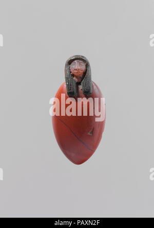 Heart amulet with human head. Dimensions: H. 5.4 cm (2 1/8 in); w. 2.7 (1 1/16 in); d. 1,5 cm (9/16 in). Dynasty: Dynasty 18 or 21-22. Date: ca. 1550-710 B.C..  This unusual looking amulet is a combination of a simplified heart and a human head. The heart, of red jasper, is depicted as a flat, oval object with slightly rounded front and back surfaces and a pointed bottom. It does not have side projections, which are known from other heart amulets that depict the organ more naturalistically. At the top is a small, carnelian human head, which was manufactured separately and attached to the heart Stock Photo