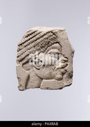 Sculptor's Trial Piece showing a Nubian Head. Dimensions: h. 10.2 cm (4 in); w. 9 cm (3 9/16 in); d. 2 cm (13/16 in). Dynasty: Dynasty 18. Reign: reign of Akhenaten. Date: ca. 1353-1336 B.C..  The heightened expressiveness with which the sculptor depicted the ethnic features of a Nubian (a native of the area south of Egypt) is characteristic of the art of Amarna. In particular, this work is reminiscent of the images of Nubians and West Asians found in Haremhab's tomb at Saqqara, which he built for himself while he was still the chief of Tutankhamun's army. Museum: Metropolitan Museum of Art, N Stock Photo