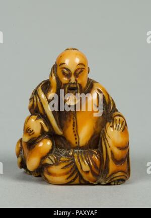 Netsuke of Seated Figure of Old Man with a Dog. Culture: Japan. Dimensions: H. 1 1/4 in. (3.2 cm). Date: 19th century. Museum: Metropolitan Museum of Art, New York, USA. Stock Photo