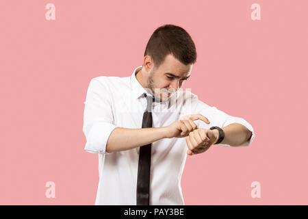 Handsome businessman checking his wrist-watch isolated on pink background. Wow. Attractive male half-length front portrait. Young emotional surprised  Stock Photo