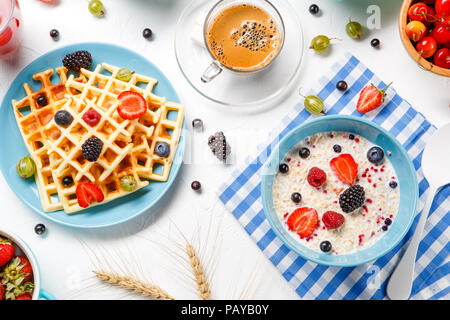 Photo of Viennese waffles, oatmeal, coffee, raspberries, strawberries, gooseberries Stock Photo