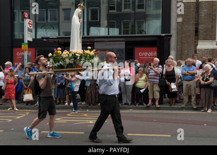 Virgin Mary statue carried in procession UK.  Italian community annual procession in Honour of Our Lady of Mount Carmel. St Peters Italian Church, Clerkenwell, London people watching religious statues pass by. 2018 2010s HOMER SYKES Stock Photo