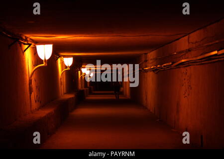 Silhouette of a man walking through the passage lighted by lanterns Stock Photo