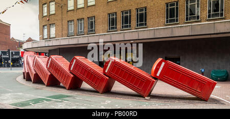Part of David Mach's art installation 'Out of Order' (1989) featuring falling over traditional red telephone boxes, in Kingston Upon Thames, England Stock Photo