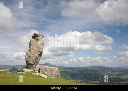 The Lonely Sheperd looking over the Usk Valley with the Sugarloaf mountain behind. A piller of limestone left by the workers at the limestone quarry. Stock Photo