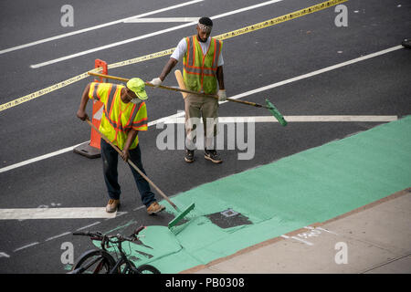 Workers for the New York Department of Transportation (DOT) paint the bicycle lane, after a recent repaving, on Ninth Avenue in the New York neighborhood of Chelsea on Monday, July 16, 2018.  (© Richard B. Levine) Stock Photo