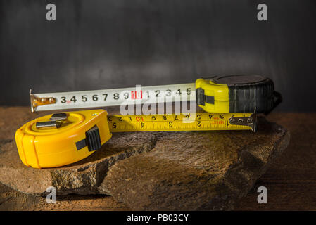 Measure tapes on the stone and dark background Stock Photo
