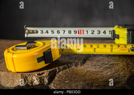 Measure tapes on the stone and dark background Stock Photo