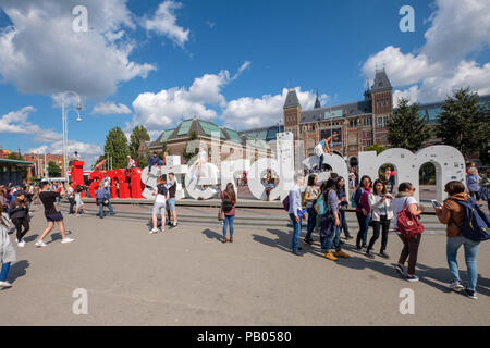 Tourists in front of the i Amsterdam sign on the Museum Square in Amsterdam Stock Photo