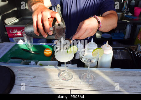 Close-up of a pair of hands serving a cocktail - John Gollop Stock Photo