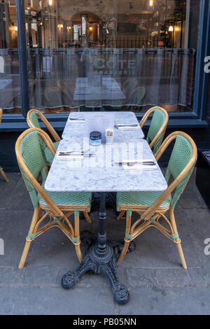 Table and chairs outside a restaurant Stock Photo