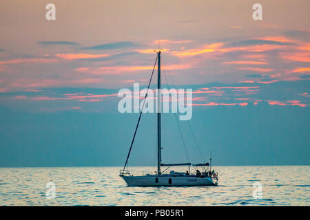 Trieste, Italy, 25 July 2018. A sailboat returns to the northern Italy port city of Trieste at sunset.  Photo by Enrique Shore Stock Photo